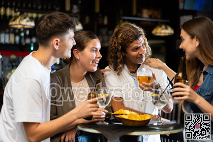 Positive men and women drinking beer and chatting in bar
