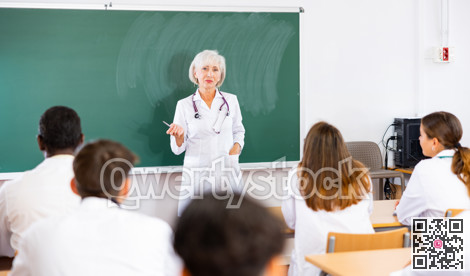Female doctor explaining new theme to adult students during class in university