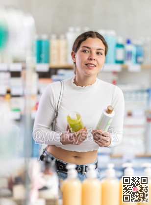 Female shopper in summer clothes chooses medicated shampoo at pharmacy