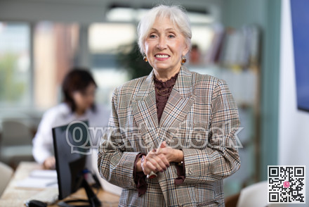 Mature woman welcoming clients at workplace