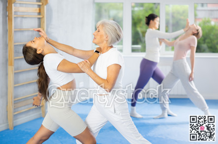 Senior woman using palm to launch blow in chin in sparring during self-defense training