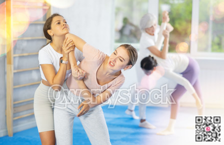 Young girl trying to escape rear grab and striking chin with elbow during self defense course