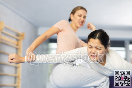 Two young women training self-defense techniques