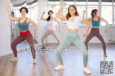 Active women practicing lindy hop movements in dance class