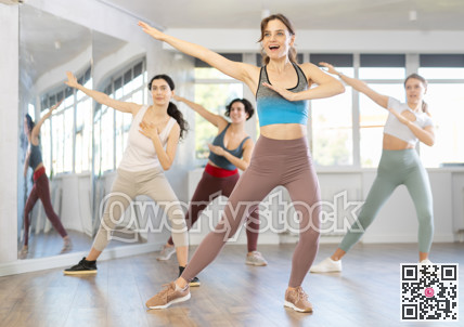 Positive females funk jazz dancers exercising dance moves in studio