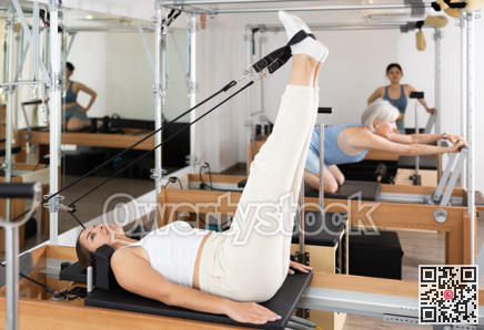 Young girl performing set of pilates exercises on reformer
