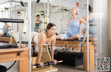 Woman pilates stretching sport in reformer bed