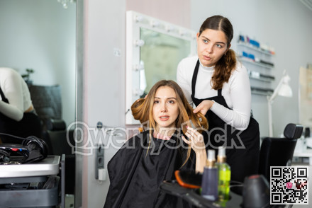 Young woman client is discussing a haircut with a hairdresser