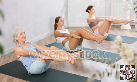 Three generation of women perform sitting lightweight variation of boat pose Paripurna Navasana