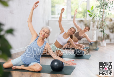 Positive women three generations posing with soft ball pilates at group class in yoga studio