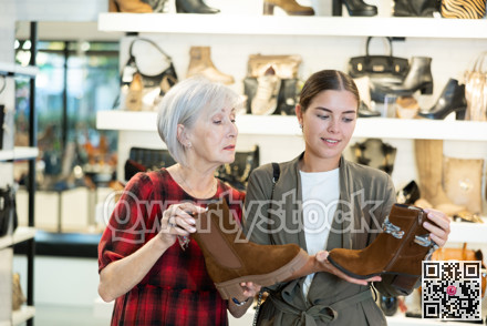 Two female shoppers discussing models of demi-season boots in store