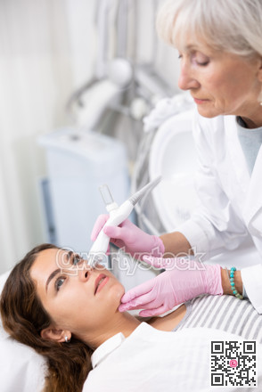 Young woman having face vacuum cleaning procedure