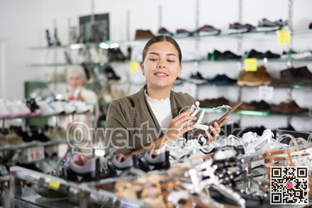 Girl client is demanding to inspect sandals in shoe showroom