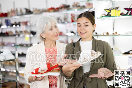 Two female friends and colleagues consult with each other about buying flip-flops or sandals