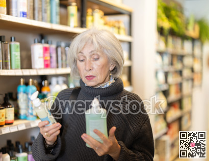 Mature woman chooses a moisturizing body lotion