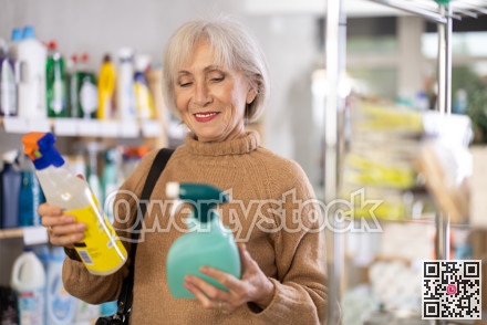 Elderly woman choosing spray in store