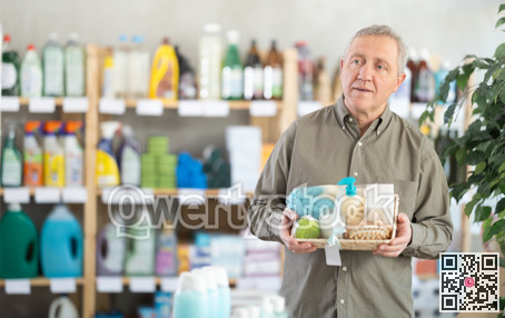 Senior man studies label and choose shower cosmetic present, packaged in basket.