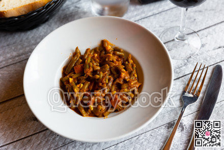 Dish of green beans with ham and tomatoes