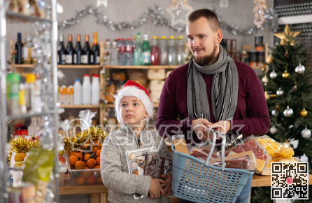 Young man with son choosing products in grocery store
