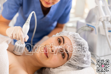 Female patient receiving hardware procedure on chest and neck area using cooling attachment