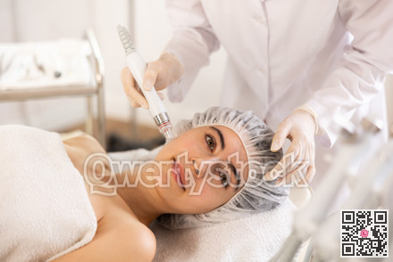 Young woman getting cosmetic facial procedure using ion bubble pen