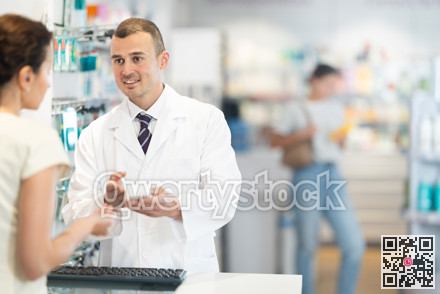 Male pharmacist speaking to woman customer buying medical preparation in drugstore