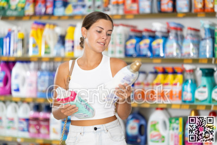 Young woman choosing detergent in store