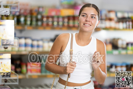 Girl in supermarket sales area looks into distance and searches for necessary goods