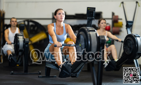 Young woman exercising on rowing machine