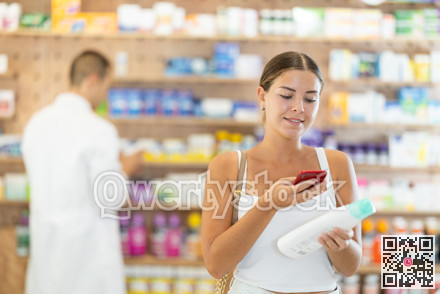 In pharmacy girl customer scans code on shampoo label, photographs packaging.