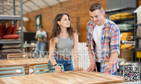 Interested couple choosing comfortable table in garden store