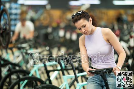 Adult woman choosing bike in store