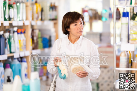 Elderly woman choosing body washcloth in store