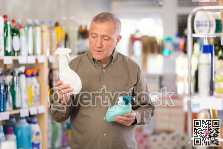 European man choosing spray in supermarket