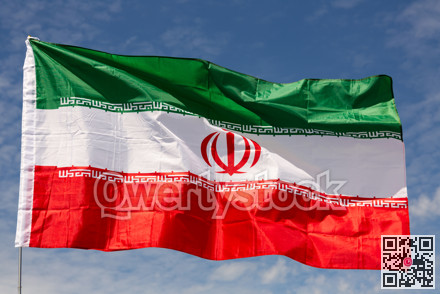 Flag of Iran waving on cloudy sky during daytime