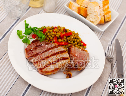 Fried beef served with peas and peppers