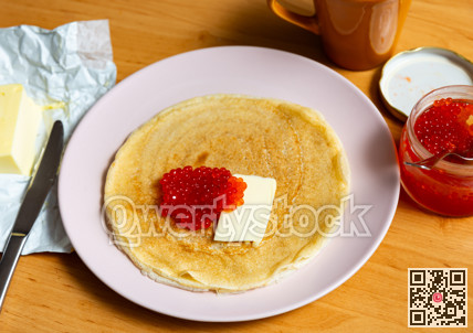 Pancakes served with red caviar and butter
