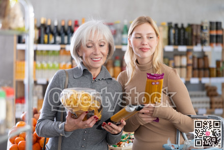 Family shopping at supermarket - choosing spaghetti and pasta in grocery section