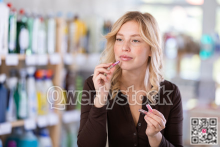 Girl housewife in cosmetic store examines goods, chooses facial powder