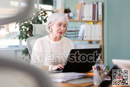 Elderly businesswoman, senior manager, work on laptop in modern company office