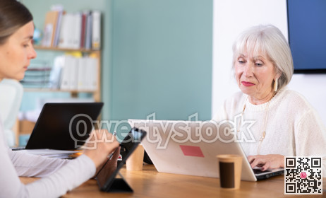 Elderly and adult women working in office