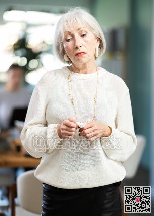 Sad mature woman staff stands in office