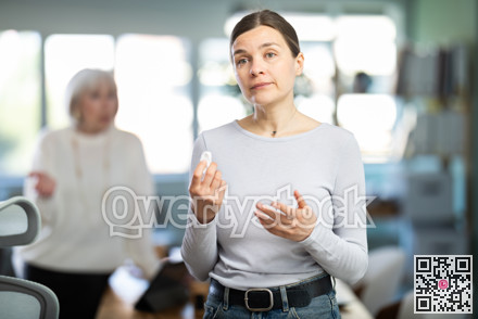 Sad woman staff stands in office