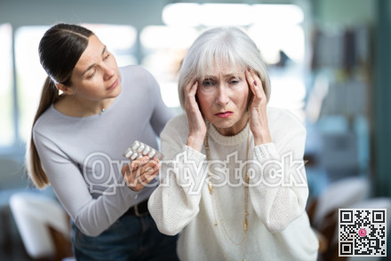 Adult woman sympathizes to sick senior female manager with headache and offers pain pills.
