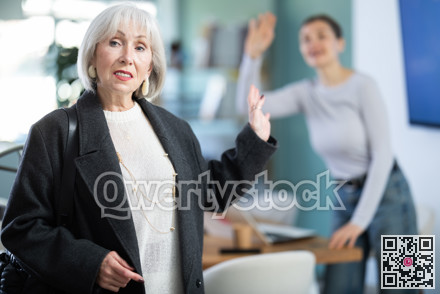 Senior woman says goodbye to colleague at end of working day