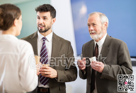 Girl with two men colleagues chat and laugh during coffee break