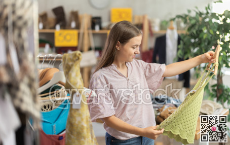 Teenage girl choosing top in clothing store