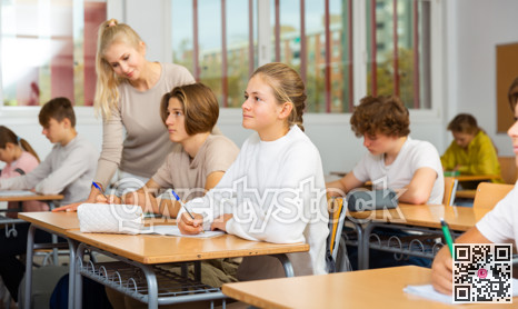 Teenagers sitting at desks in classroom during lesson