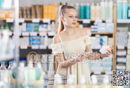 Girl in summer clothes looking for medicine in pharmacy