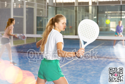 Young girl with racquet playing padel